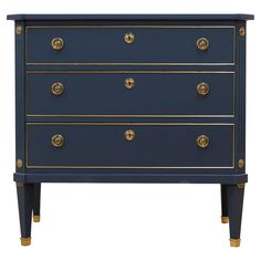 a blue and gold chest of drawers with brass knobs on the bottom, one drawer open