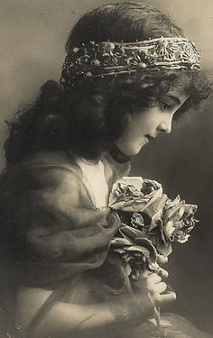 an old photo of a woman holding flowers