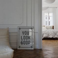 a white room with a bed and a poster on the floor that says you do something