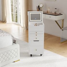 a white dresser sitting in front of a desk with a monitor on top of it