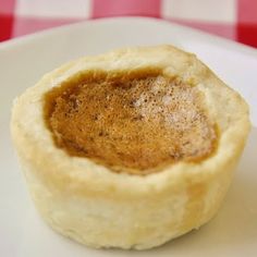 a small pastry on a white plate with a red and white checkered tablecloth