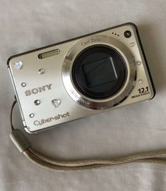 a silver camera sitting on top of a bed