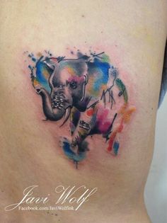 an elephant painted on the side of a woman's stomach with paint splatters all over it