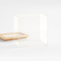 two clear acrylic boxes with wooden trays on the bottom one is empty