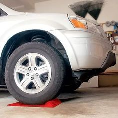 a white car parked in a garage next to a red stop sign on the ground