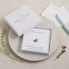 an engagement ring sits in a box on a plate next to some cards and flowers