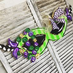 two decorated hats sitting on top of a green and black plate next to each other