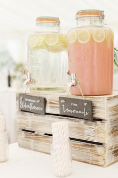 two mason jars filled with lemonade sitting on top of a wooden crate next to each other