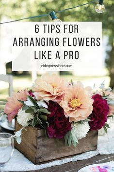 a wooden box filled with flowers on top of a table