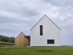 a white house sitting on top of a lush green field