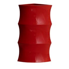 a large red vase sitting on top of a white wall