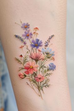 a woman's thigh with flowers painted on the side and behind her is a tattoo