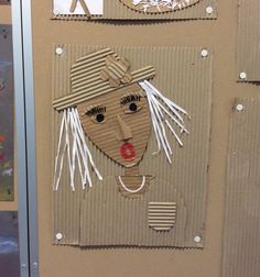 cardboard cut out of a woman's face on a bulletin board with paper strips