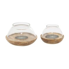 two clear glass vases with wooden lids on each one, both filled with water