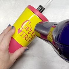 a person is using a hair dryer on top of a table with a cup