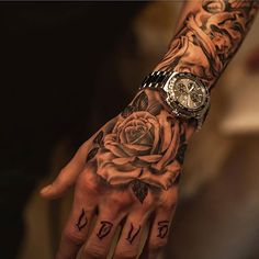 a person with tattoos on their arm and hand is holding a rose tattooed on the wrist