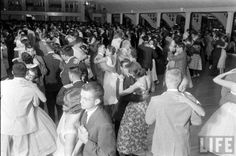 a group of people standing around each other on a dance floor in front of a crowd