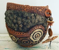 an artistically designed ceramic bowl with beads and wood bead accents on the sides