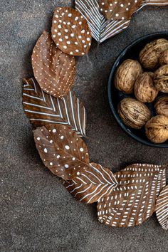 a bowl filled with nuts sitting on top of a cement floor next to a decorative wreath