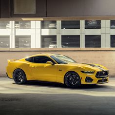 a yellow sports car parked in front of a building