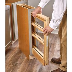 a man is holding the door to his kitchen cabinet