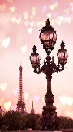 the eiffel tower is seen in black and white, with hearts floating over it