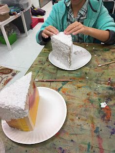 a woman sitting at a table with two pieces of cake