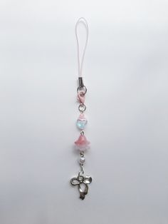 a key chain with a cross and beads hanging from it's side on a white background