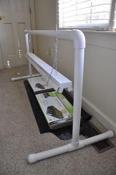 a white swing set sitting on top of a carpeted floor next to a window