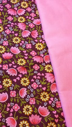 pink and brown fabric with floral designs on the bottom, laying next to each other