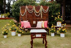 a wooden bench sitting in the middle of a lush green field next to yellow flowers