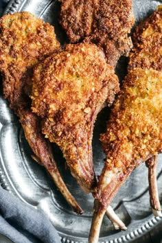 three pieces of fried meat on a metal plate