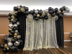 black and gold balloon arch with sheer curtains