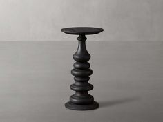 a tall wooden table sitting on top of a cement floor next to a white wall