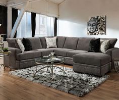 a living room filled with furniture on top of a hard wood floor covered in rugs