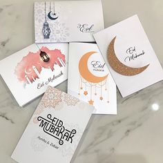 five different greeting cards on a marble surface with the words eid mubara written in arabic