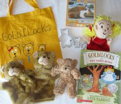 stuffed animals and books on a bed with a tote bag in the foreground