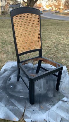 a chair sitting on top of a tarp in the middle of a field next to a tree