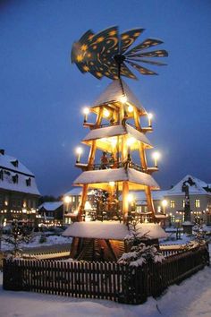 a christmas tree is lit up in the snow