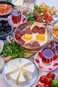 a table full of food including eggs, sausages and cheese