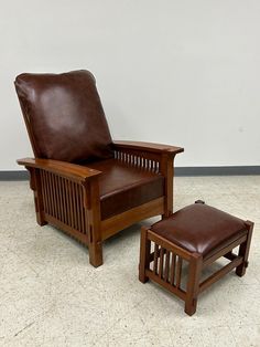 a brown leather chair and footstool sitting next to each other