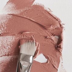 a close up of a paintbrush with some pink colors