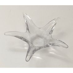 a clear glass star shaped object on a white surface