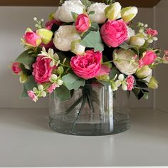 a vase filled with lots of pink and white flowers