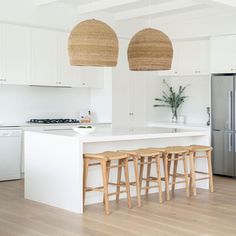 a kitchen with white cabinets and wooden stools