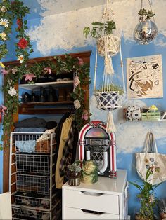 a room with blue walls and various items hanging on the wall, including baskets, plants, and other decorations