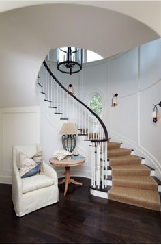 a white chair sitting in front of a spiral staircase