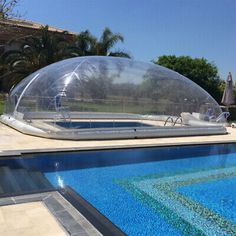 an inflatable swimming pool is shown next to a large clear bubble tent on the side of a house