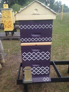 the beehive is painted purple and has white designs on it's sides