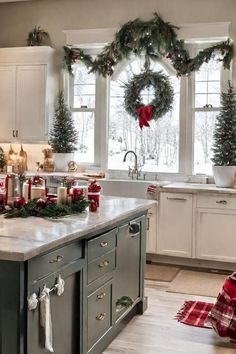 a kitchen decorated for christmas with wreaths and candles